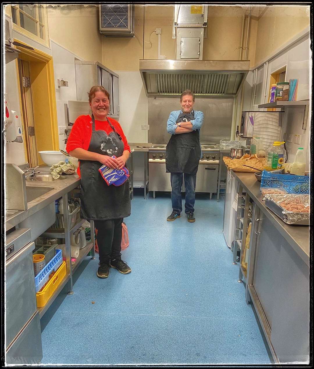 Volunteer cooks Julie White and Paul Dunn cooking takeaway meals in the newly renovated kitchen