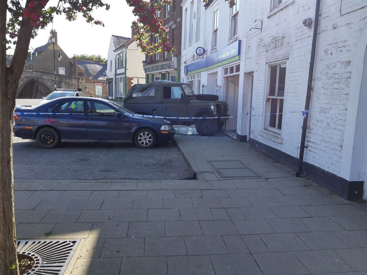 A green Land Rover is lodged in the window of the Lincolnshrie Coop store in Crowland (34378226)