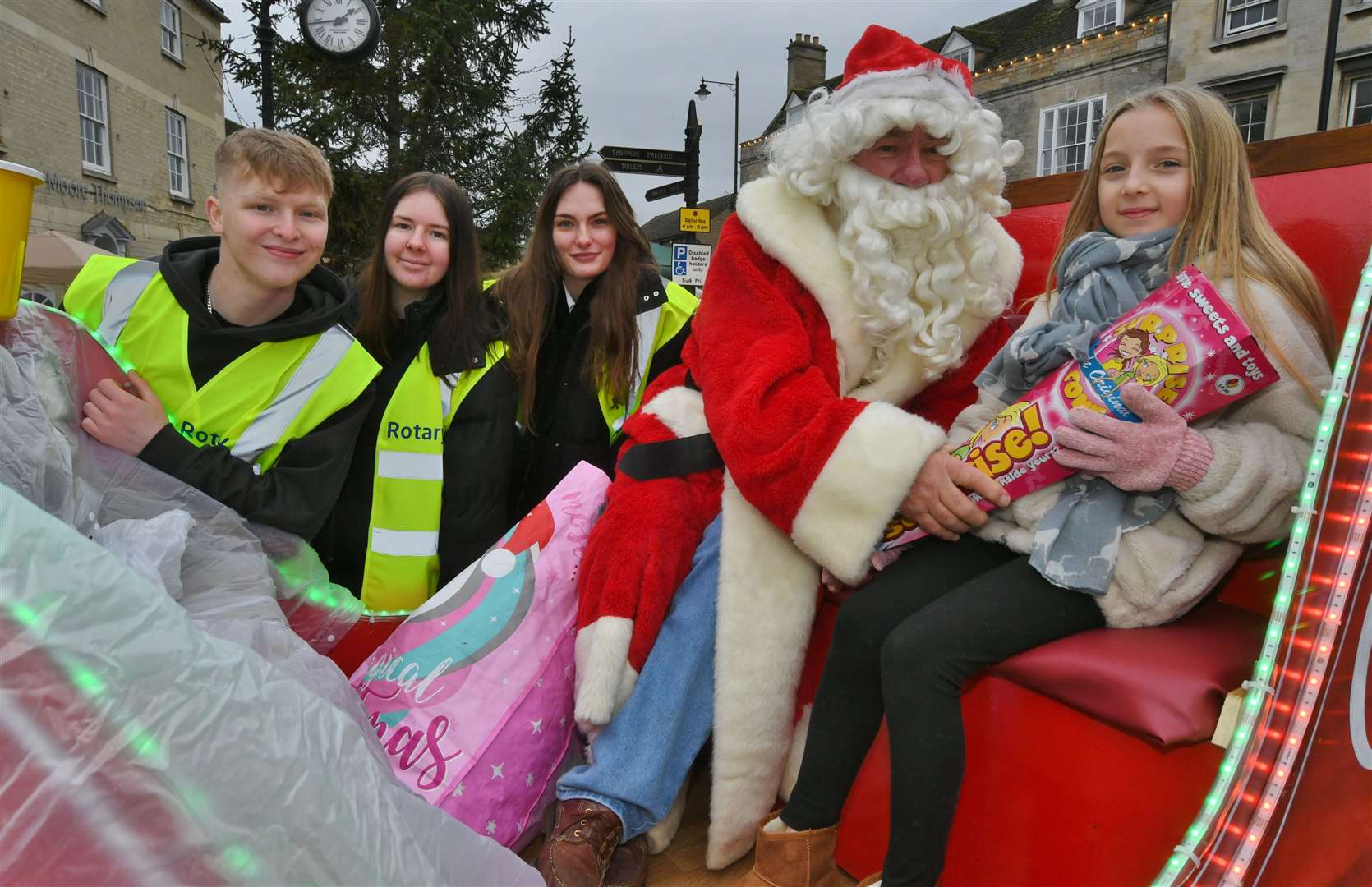 Christmas Fair at Market Deeping 2022. Deepings Rotary Club volunteers from the Deepings School 6th form Louise Taylor, Blake Robinson and Michaela Roper with Father Christmas and 10-year-old Poppy Stead