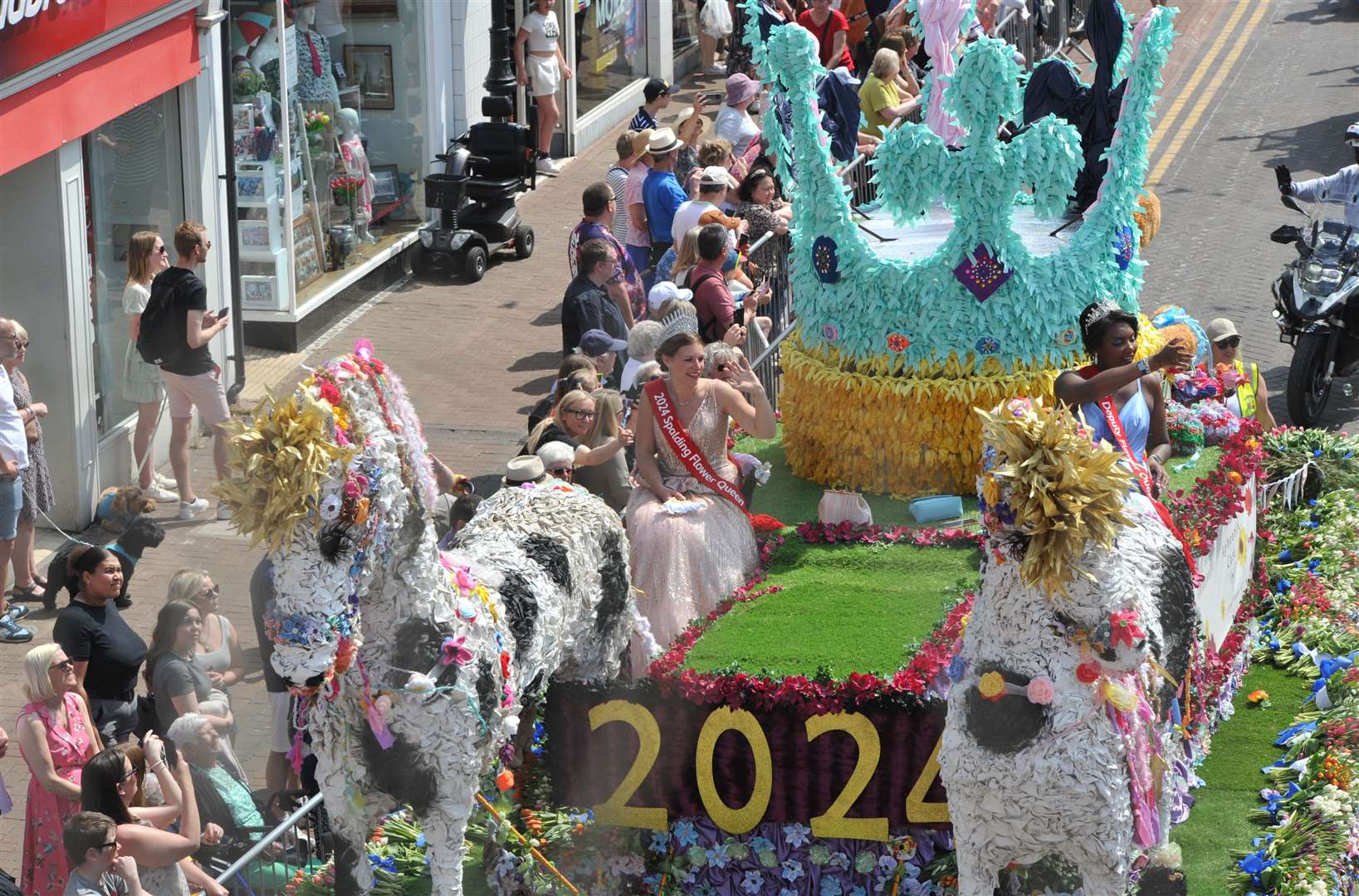 Spalding Flower Queen Becs Roberts and Deputy Demi Fontaine Gilchrist wave at the crowds as they pass through the town centre. Photo: Chris Lowndes