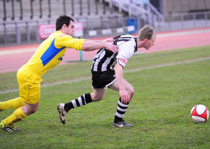 Grantham Town captain Sam Purcicoe (right) struggles to escape from a rugby-like Frickley tackle. Photo: Toby Roberts