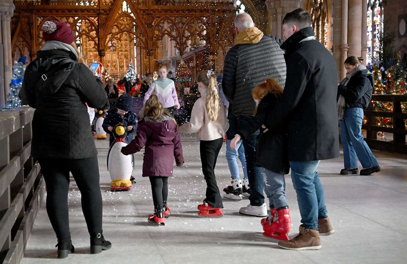 Visitors enjoying the St Wulfram's Christmas Tree Festival and skating rink.