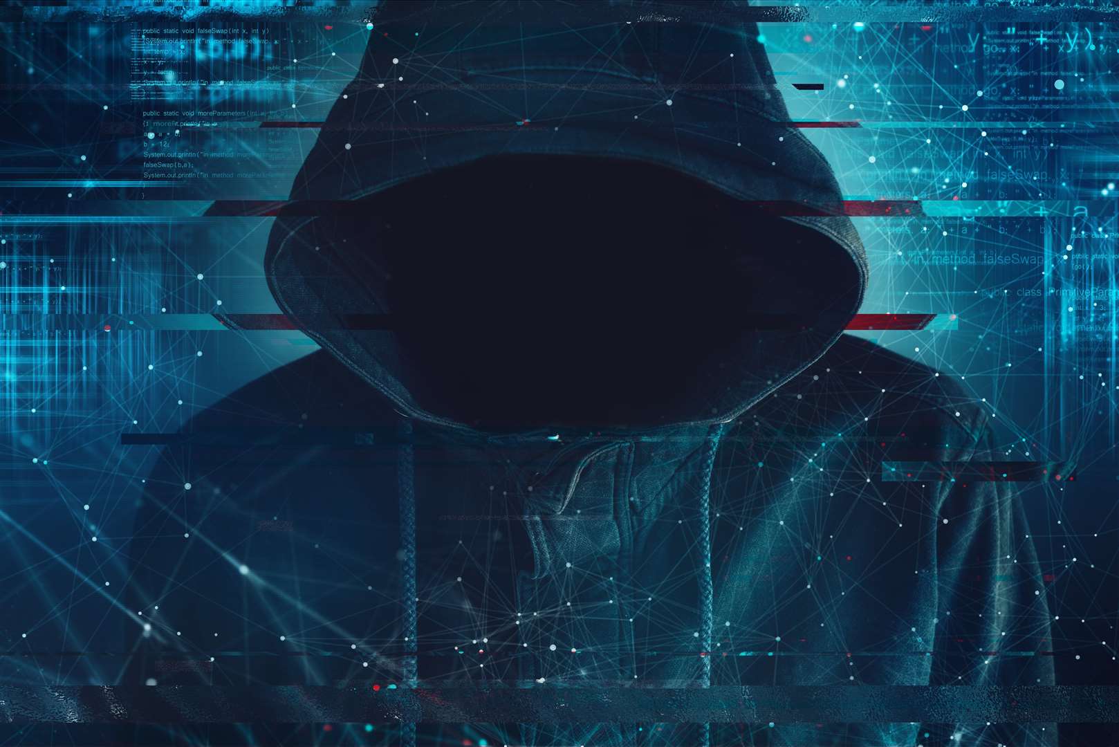 Cybersecurity, computer hacker with hoodie and obscured face, computer code overlaying image. (45305337)