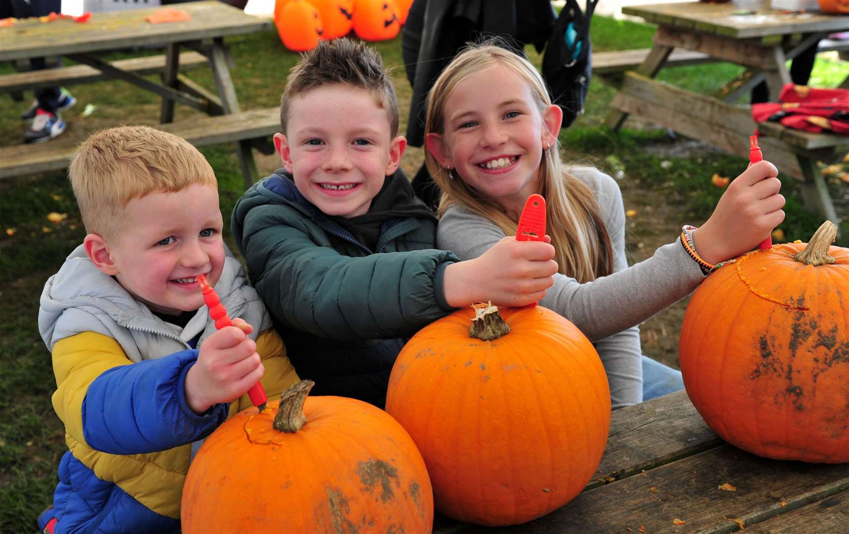 Jack Hames, George Hames and Hattie McLean carve their pumpkins. Photo: Chris Lowndes