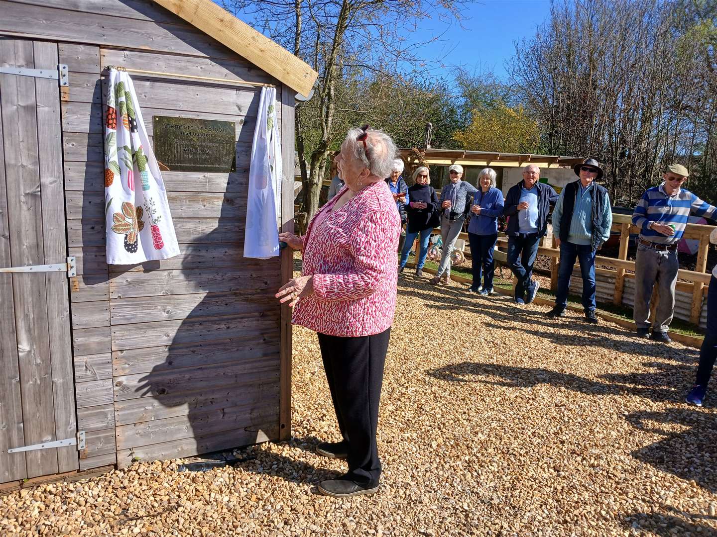 Ann Ellis unveils the plaque on the shed HQ
