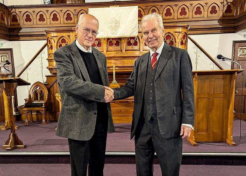 New president, Dr. Michael Gilbert OBE shaking hands with the out going president Tom Grimes