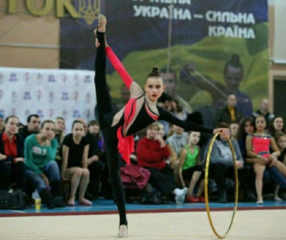 Rhythmic gymnasts perform on the floor using a ball, hoop, and ribbon