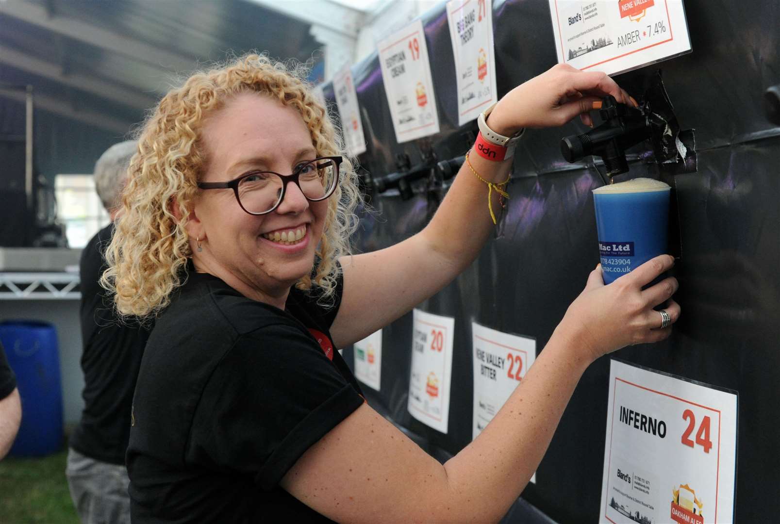 Volunteer Cathy Haron pours a pint at Bourne Festival 2023. Photo: Chris Lowndes