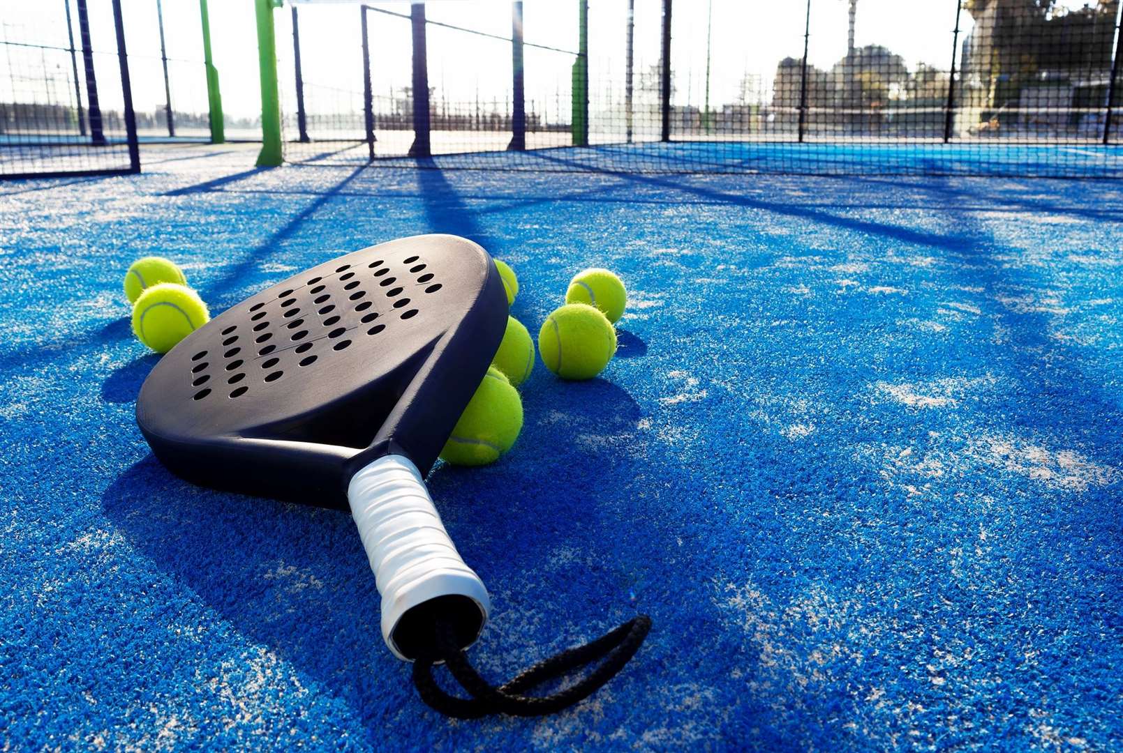 Padel racket and balls on a blue padel court. Photo: istock