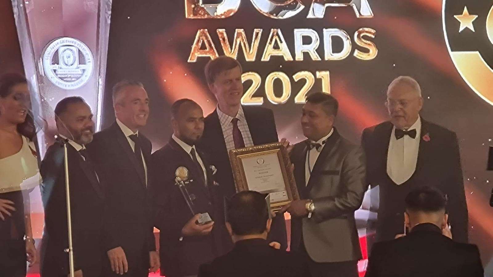 Abdul Hannan is presented with his certificate and a glass trophy