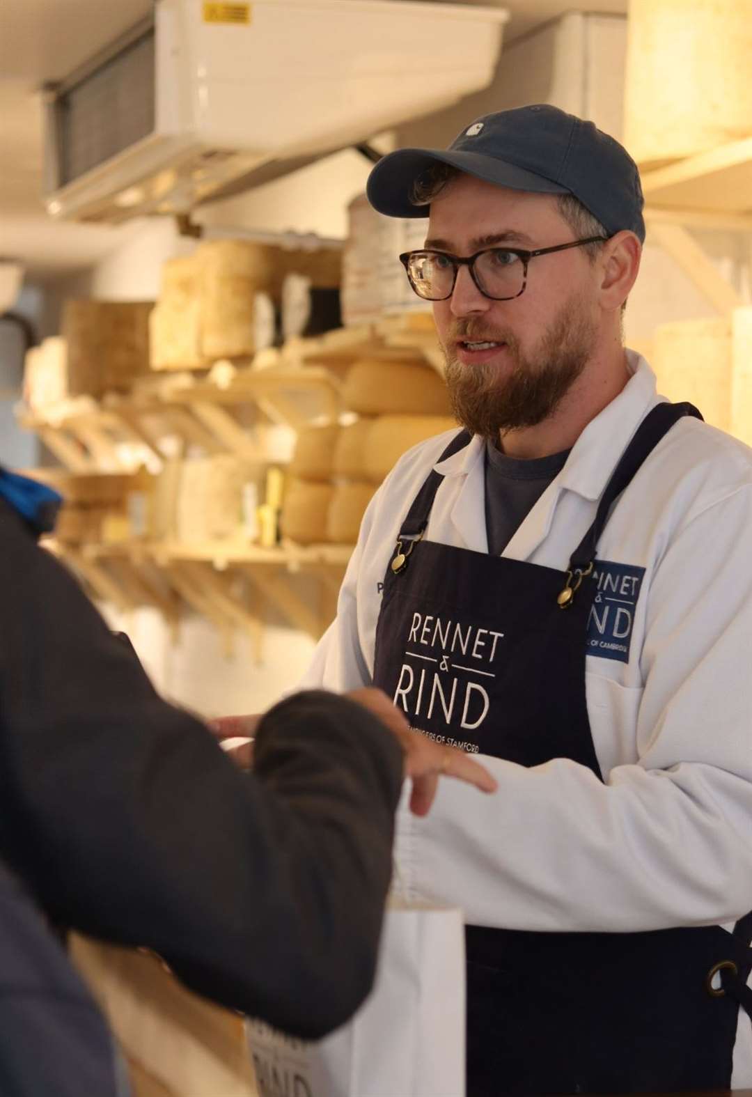 Perry James Wakeman, 'chief of cheese', serving a customer at Rennet and Rind