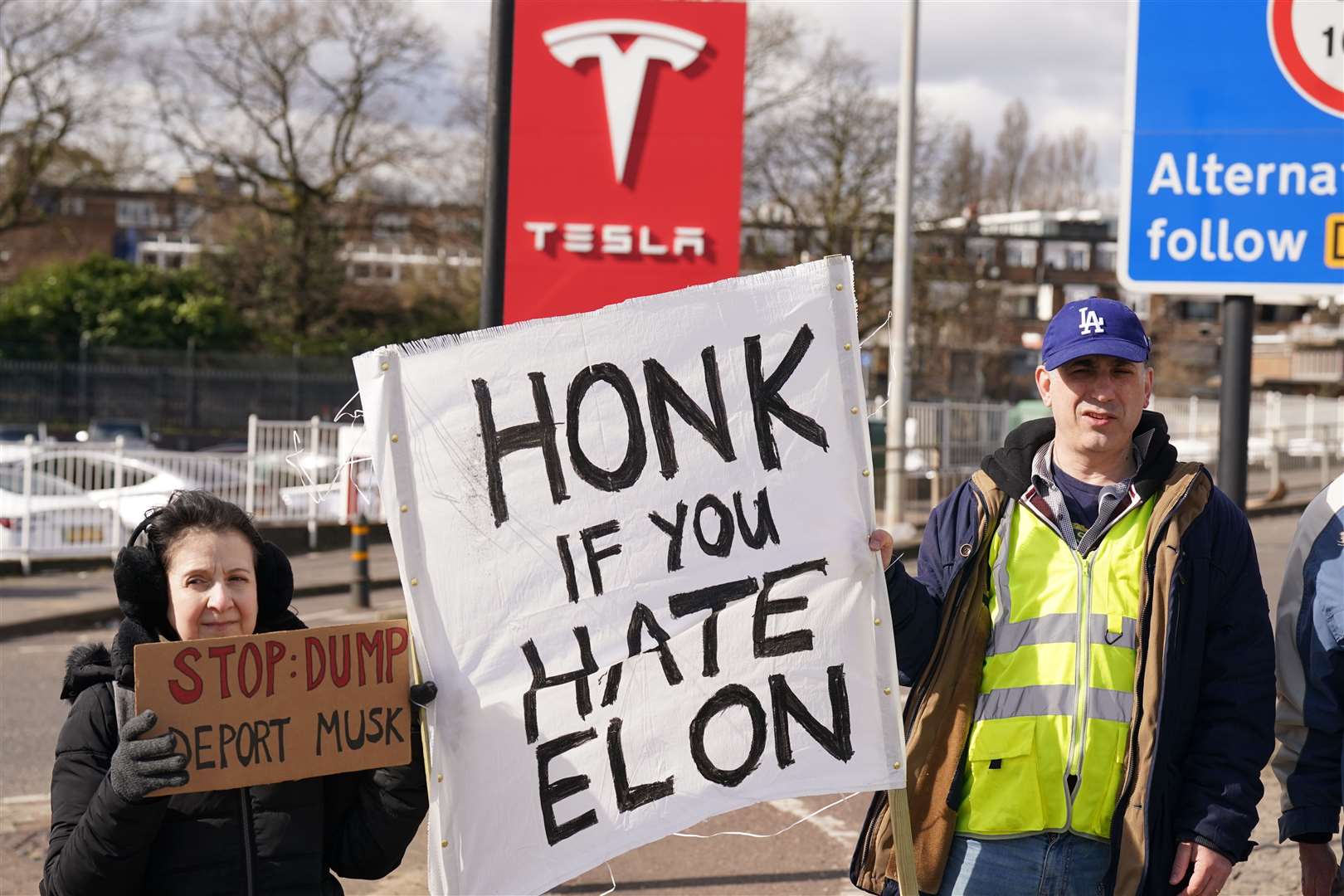 Protesters held signs that said ‘Honk if you hate Elon’ (Stefan Rousseau/PA)