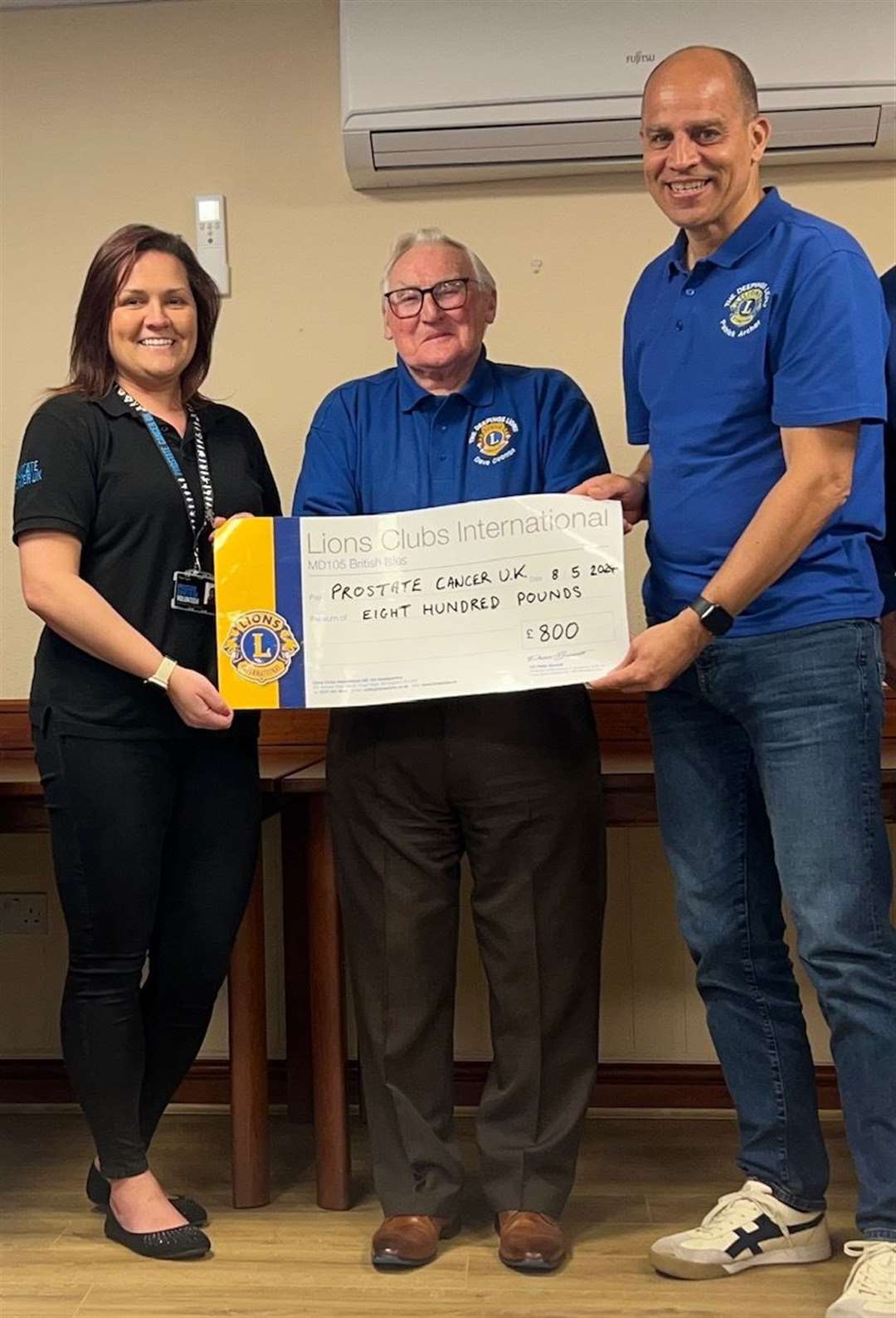 Tracy Taylor receives a donation for Prostate Cancer UK from Lions Dave Coombs and Patrick Archer