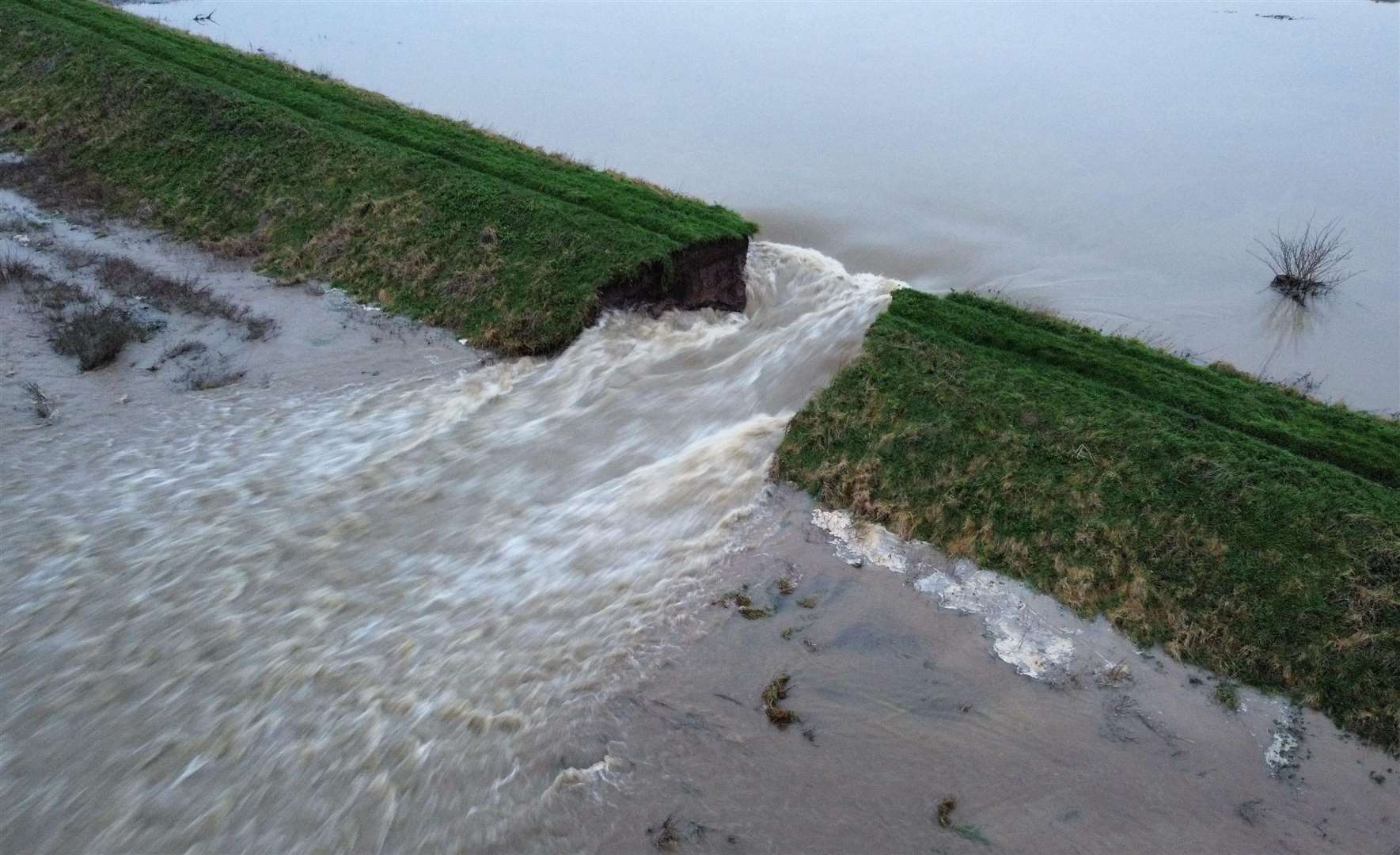 Water can be seen flooding through the breach in Welland Bank PHOTO: HADEN BRITTAIN