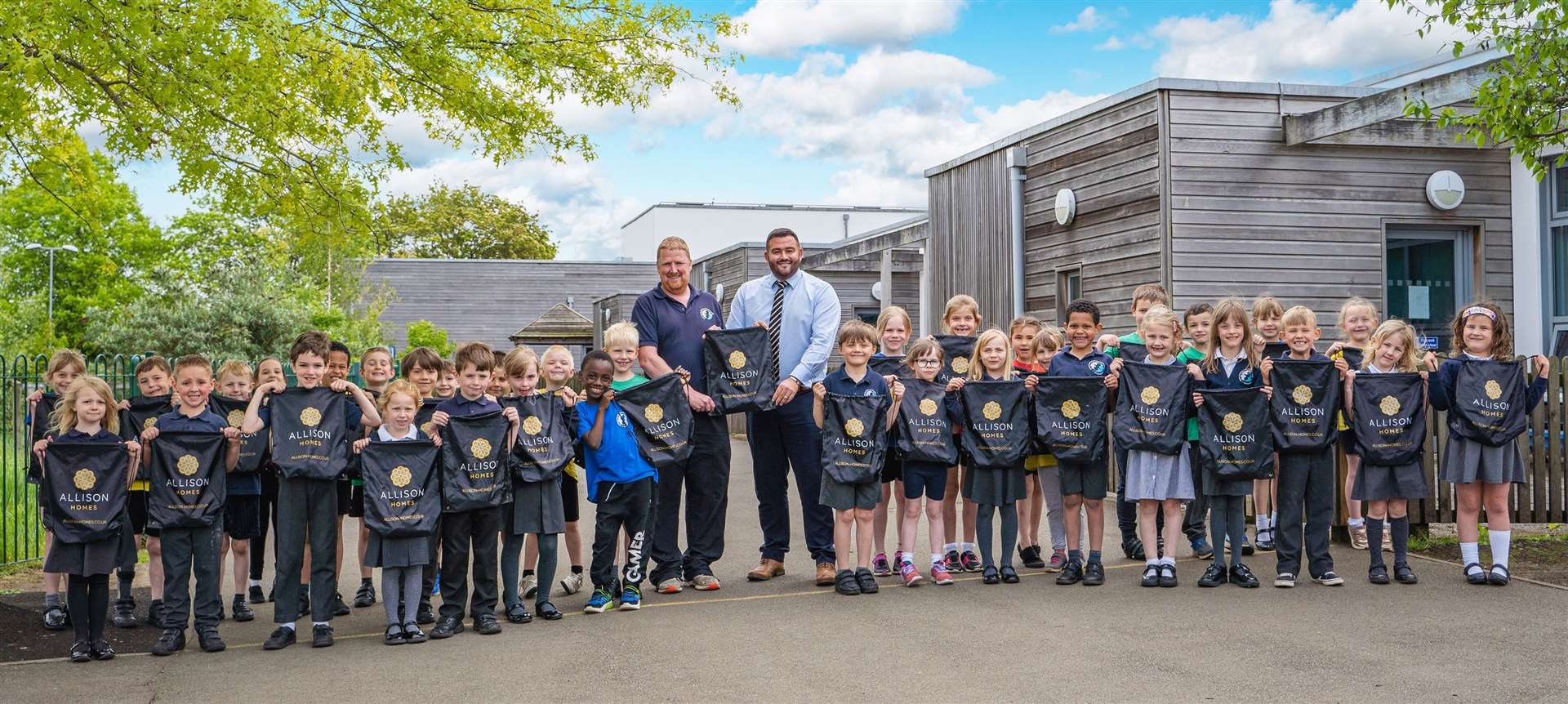 Pupils of Oakham CofE Primary School with George Knight (left) and William Wallace, of Allison Homes