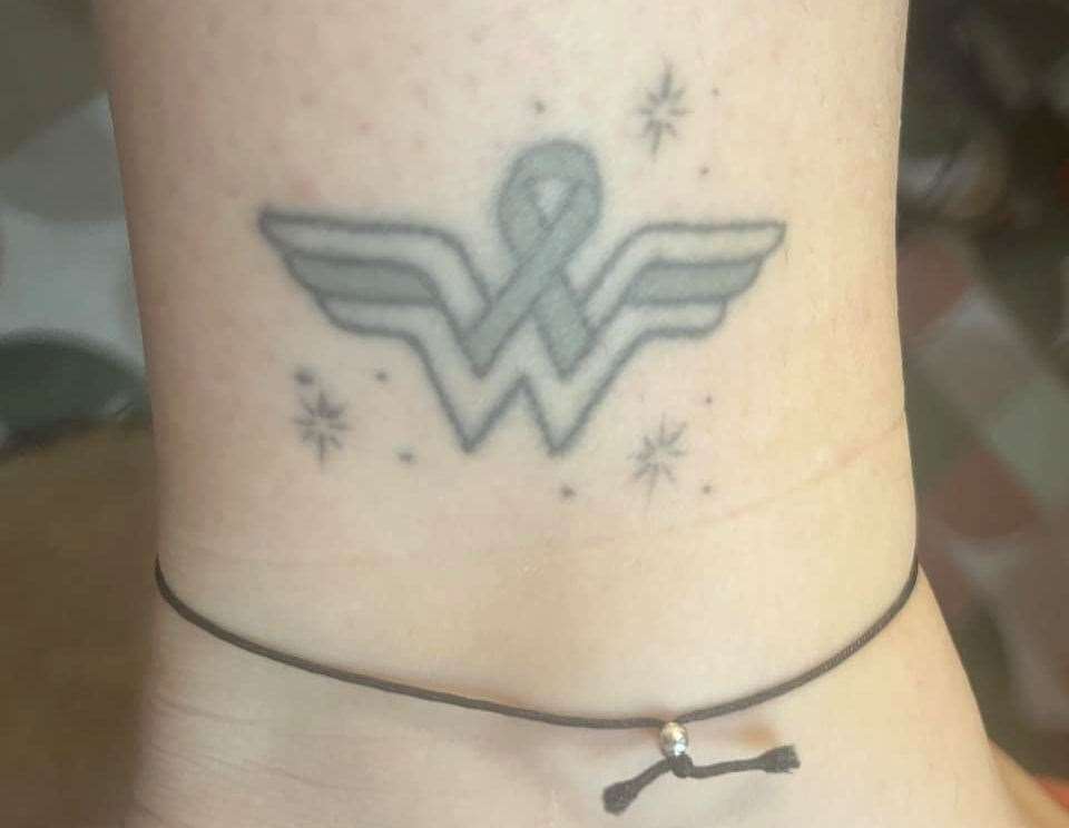 Claire's tattoo, which combines the Wonder Woman logo and brain tumour ribbon.