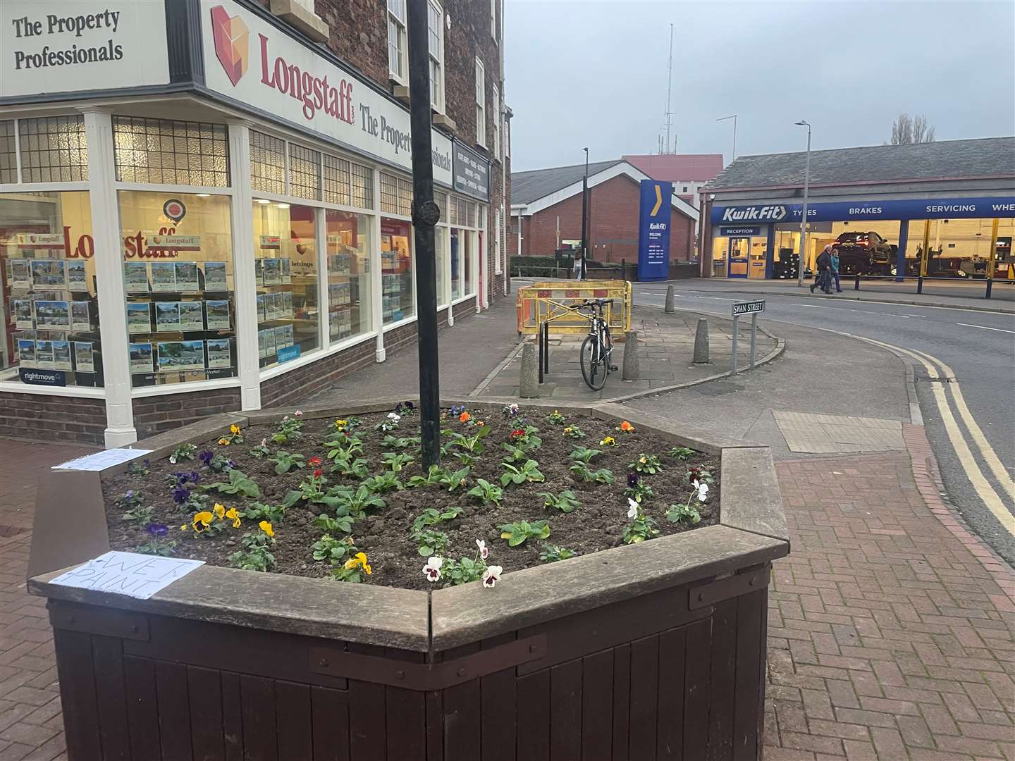 Wet paint signs are stuck to the New Road octagonal planter as work goes on