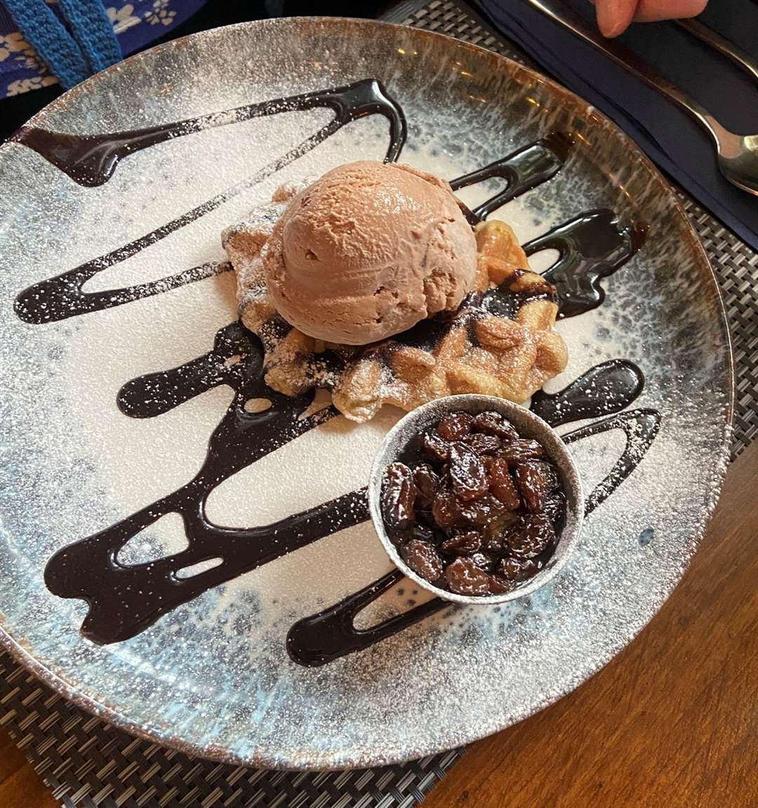 The waffle with the raisins on the side