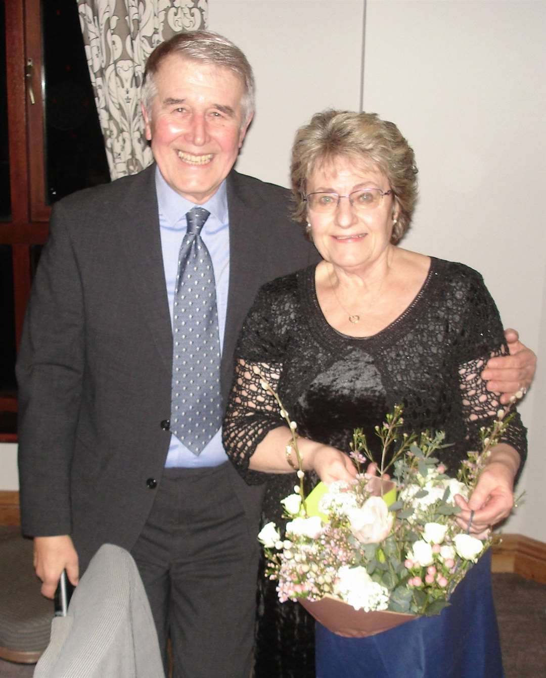 2024 captain Roy Sanders presenting Andy's wife Joy with a bouquet of flowers.