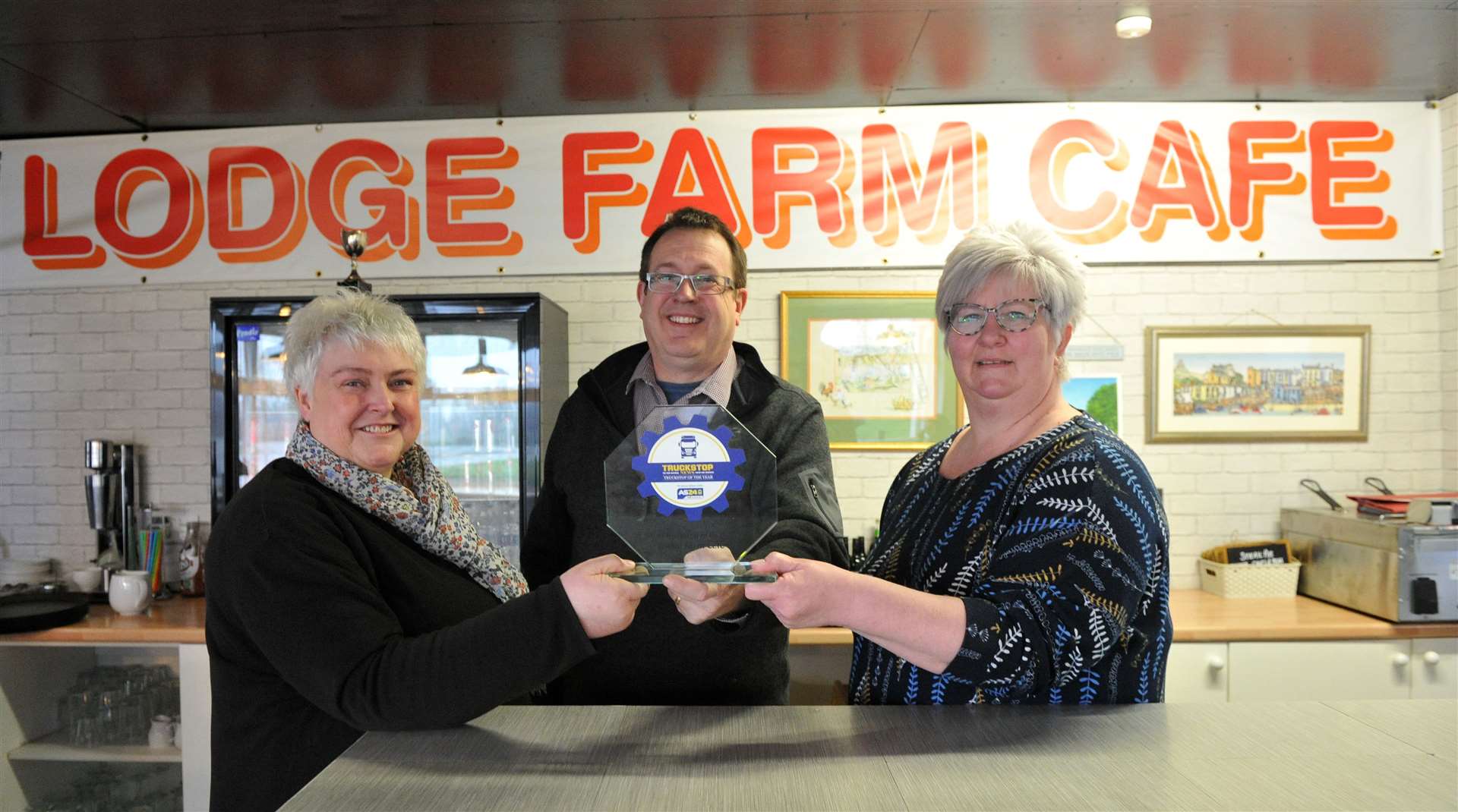 Lodge Farm Cafe owners Susan Dunn and Rebecca Chandler receive the trophy from Pip Dunn