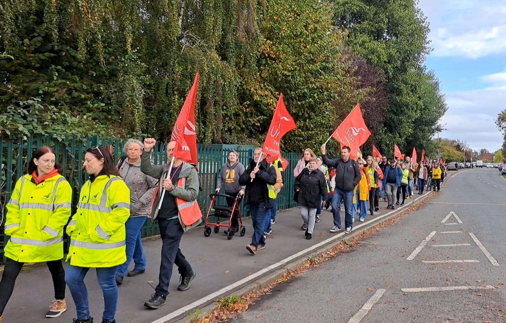 Staff wave flags and sound horns to passing drivers