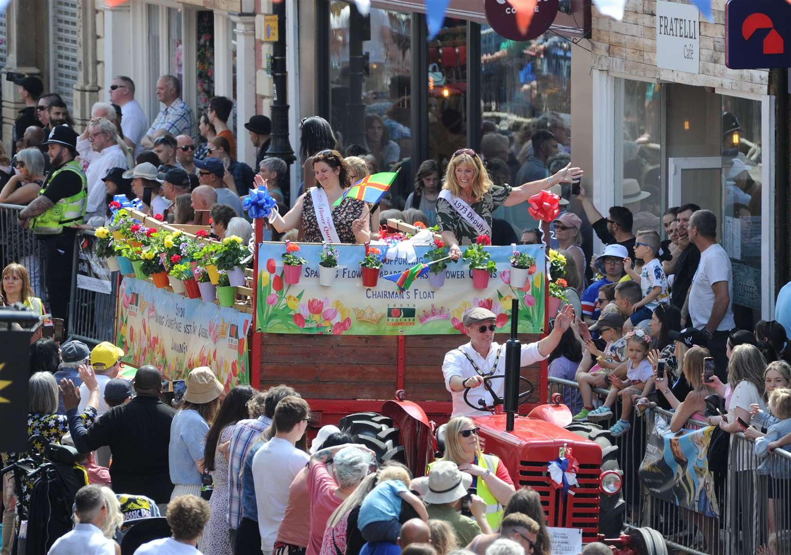 Chairman of South Holland District Council, Coun Andrew Woolf, waves to the crowds as he drives the past Flower Queens and Deputies through Hall Place PHOTO: CHRIS LOWNDES