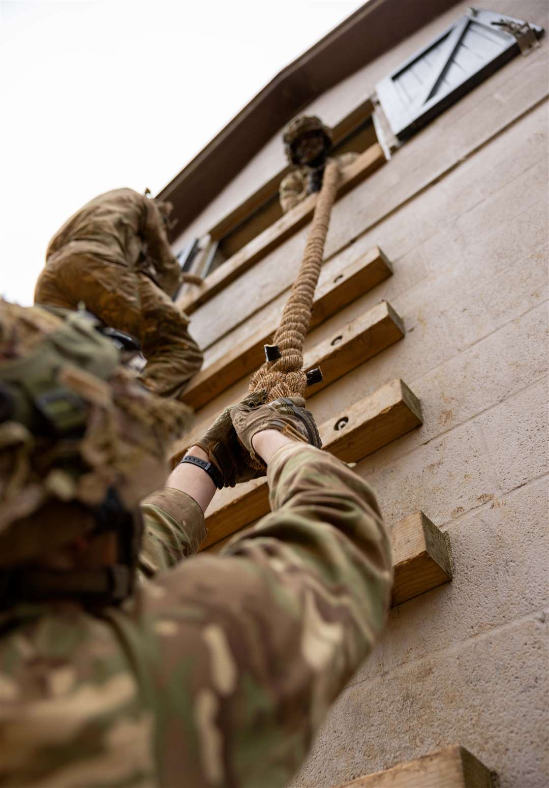 Private Henry helps a colleague climb the rope wall.