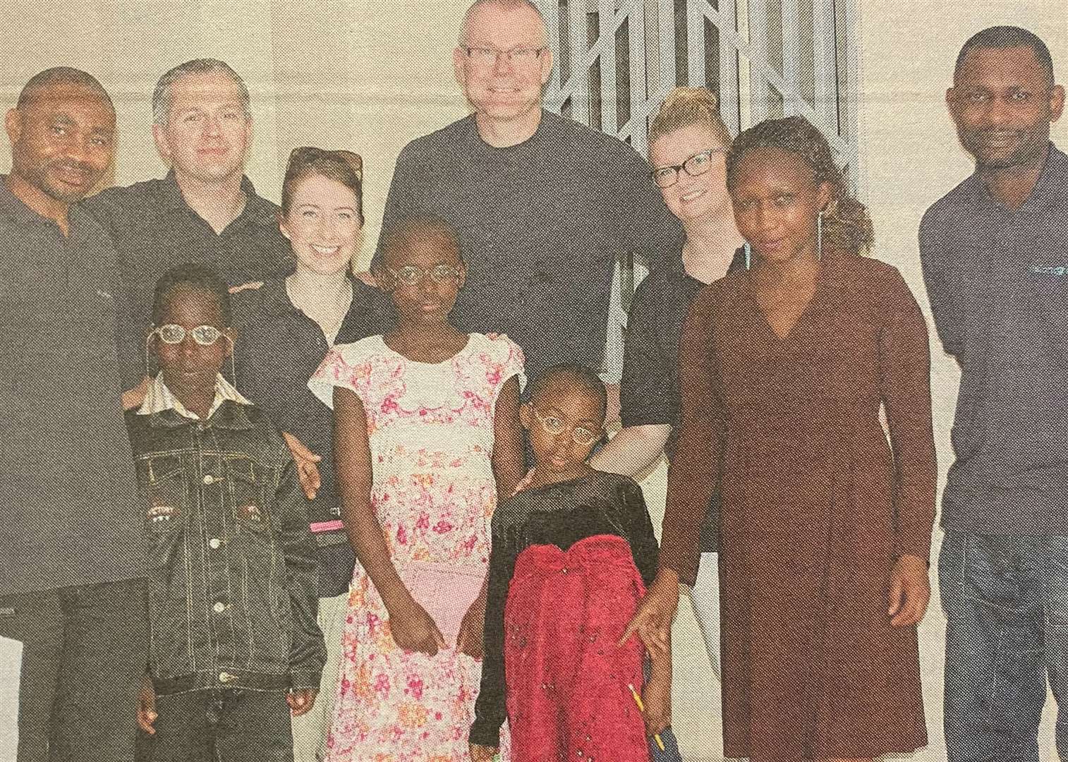 From left, Julius Winterm, Ken Macdonald, Yvonne Gilmour, Alan Gilbert, Kirsteen Angus, the children's chaperone, Beltus Etchu, and three local children all who were fitted with prescriptive glasses 10 years ago.