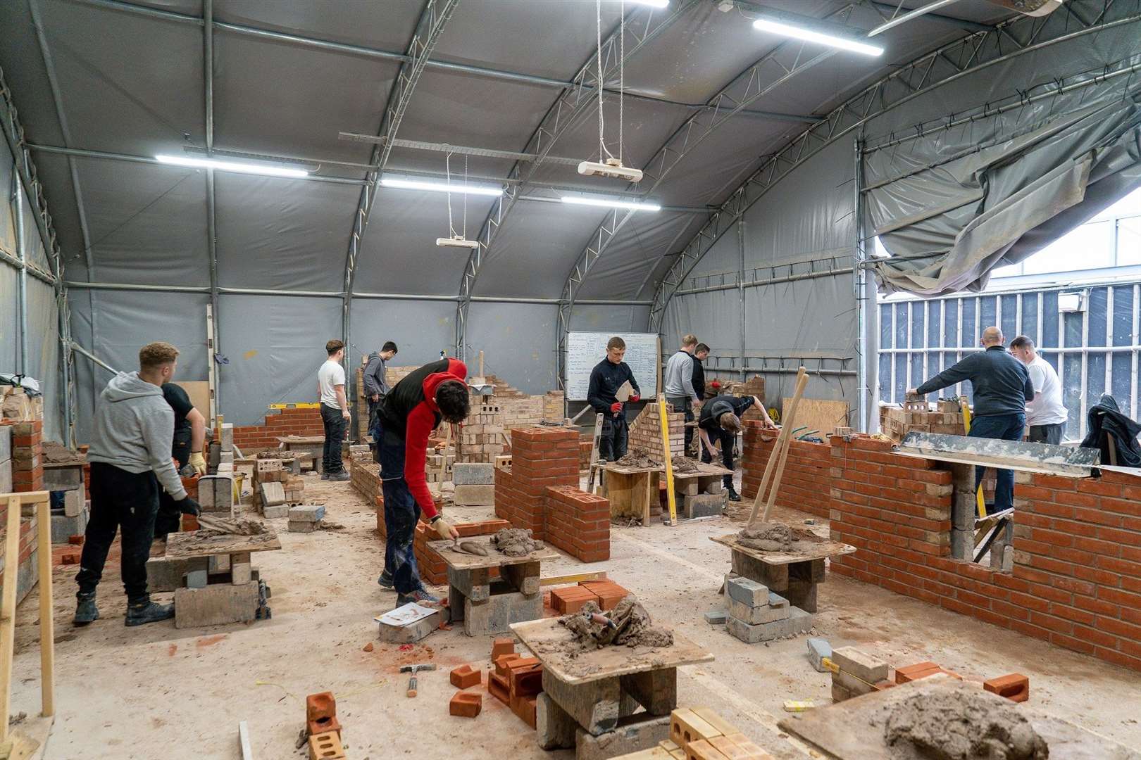 Students at Stamford School building wall structures using the bricks donated by Allison Homes