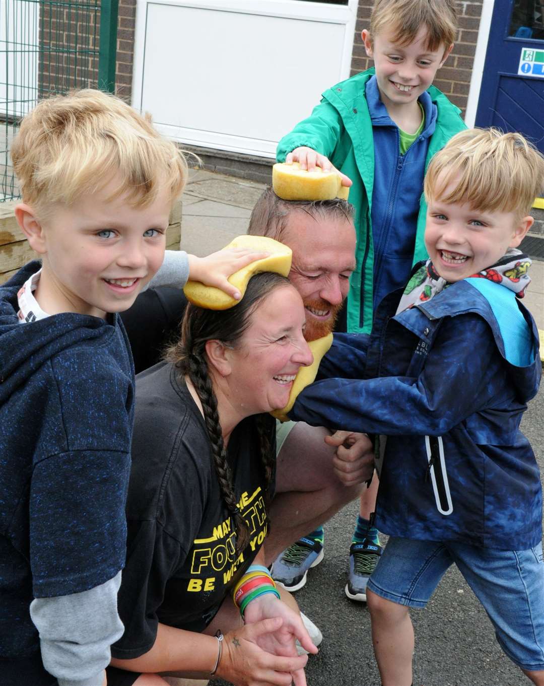 Max, Sam and William Carter sponge the teachers Katie Blades and Craig Keenan. Photo: Chris Lowndes