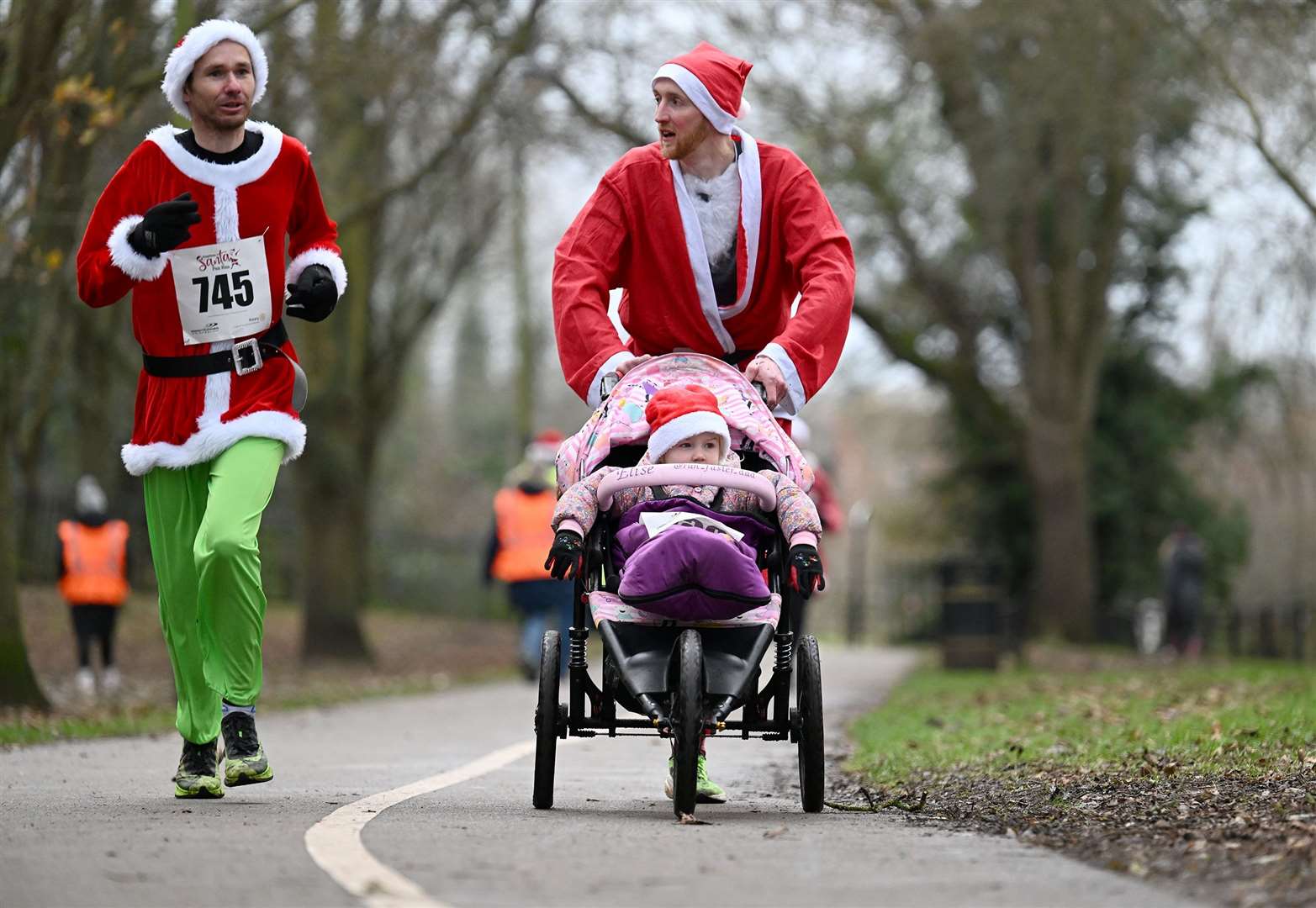 A smaller Santa getting involved in the festive spirit.