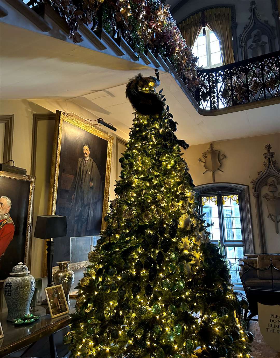 A tree topped with a peacock decoration