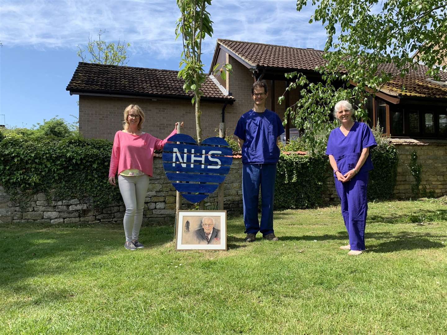 Andrea Naylor (left) presents the portrait of Captain Tom to Dr James Thorpe and Dr Alison Guthrie of Empingham Medical Centre (34730900)