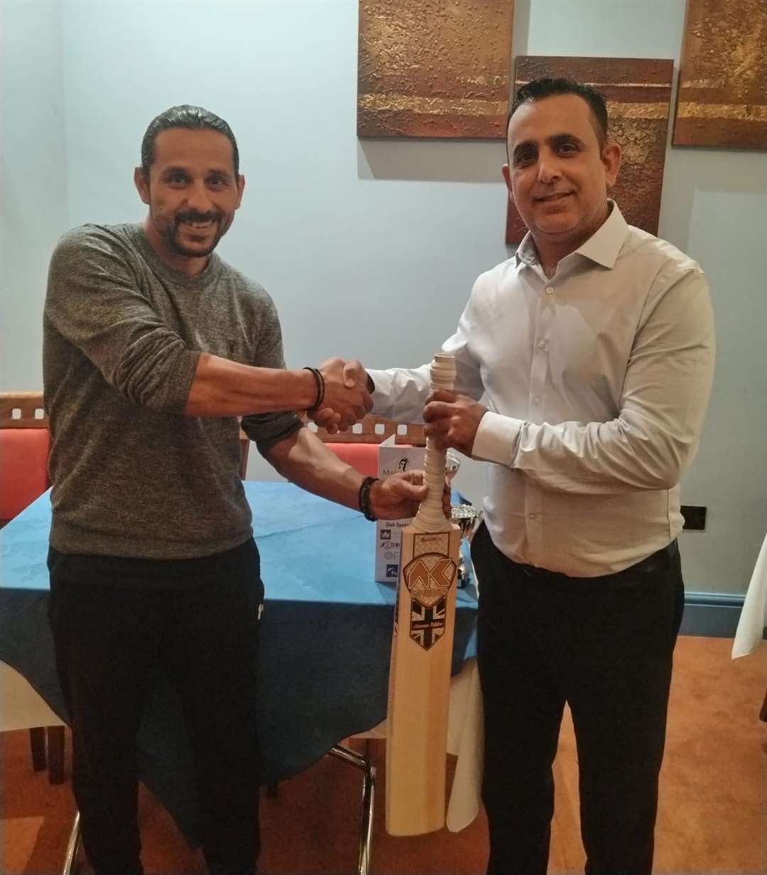Barnack captain Muhammad Yaseen presents Asim Butt with his new bat.