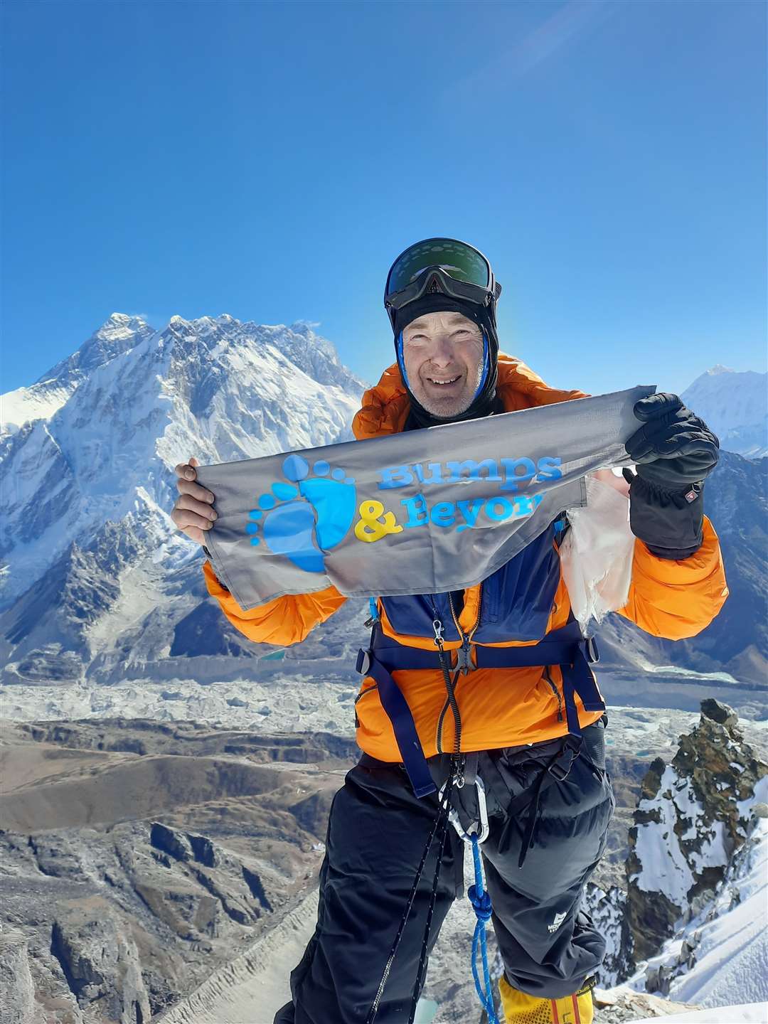 Ian at the summit of Lobuche with a reminder of what he was climbing for