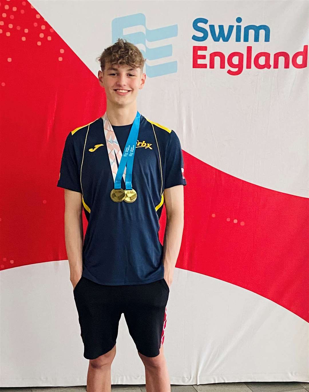 Ethan Soppett-Moss is all smiles after winning more medals and, above, swimming the butterfly