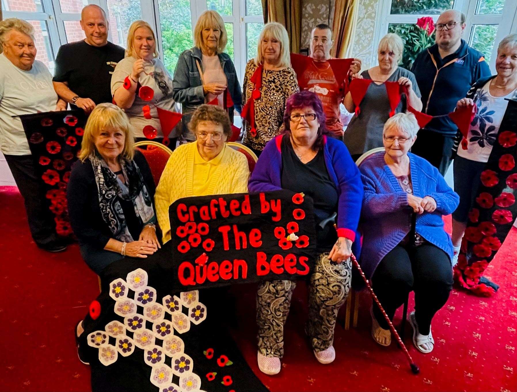 Jan (bottom left) with the Queen Bees and volunteers who have been working hard behind the scenes on the poppy display