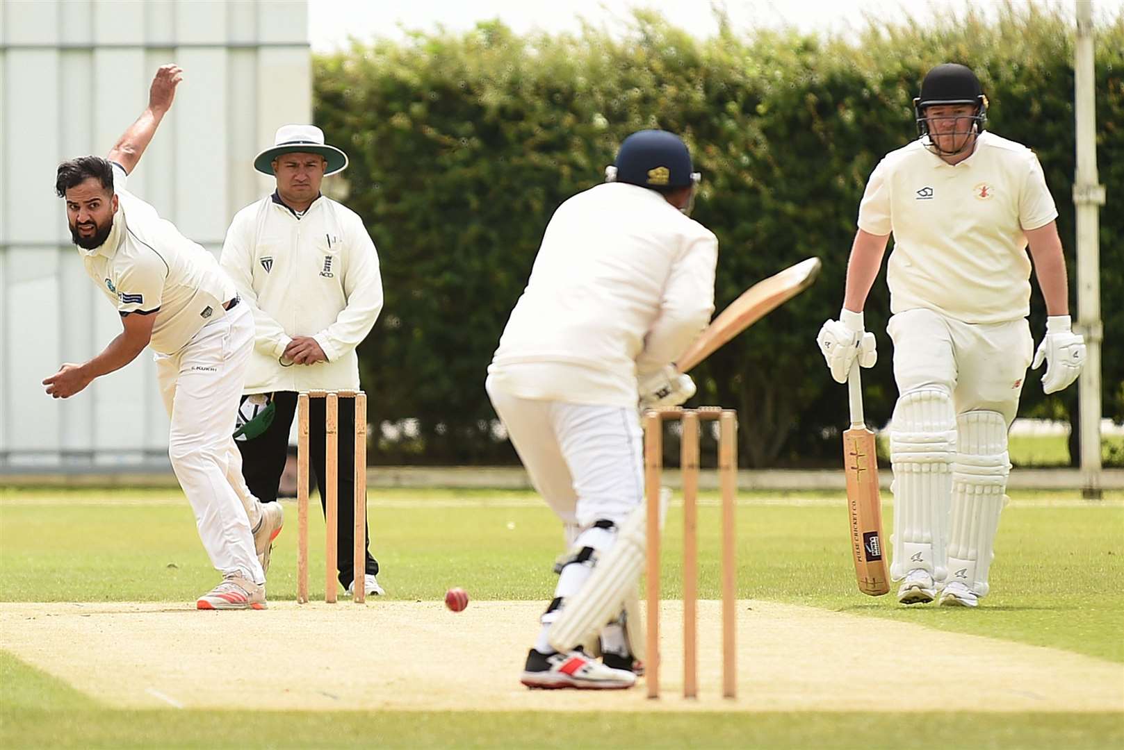 Faizan Minhas sends down a delivery.