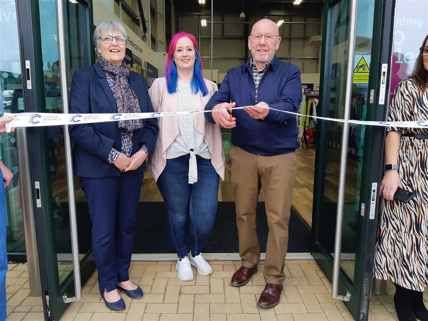 Steve Bent, right, cuts the ribbon with his wife, Sue, and shop manager Fiona
