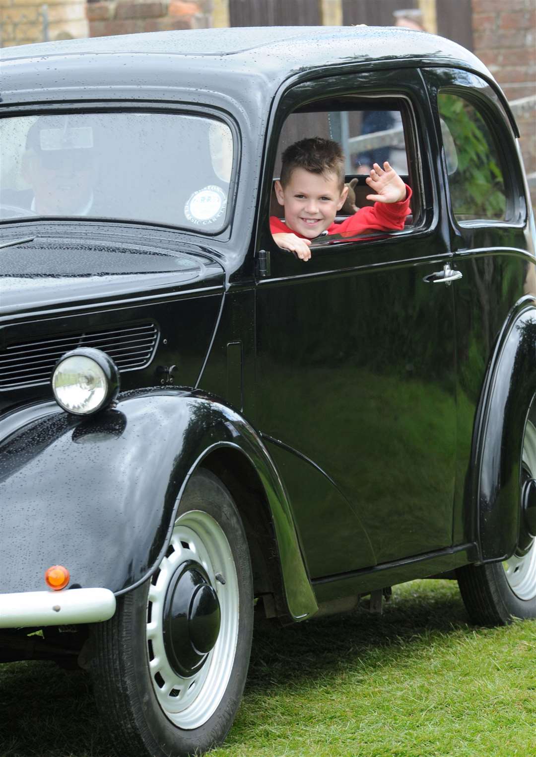 A wave from this youngster in a classic car
