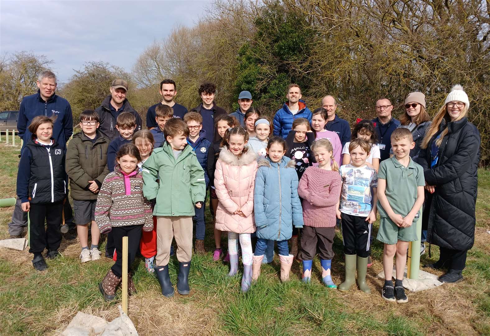 Children from St Gilbert's CE Primary School eco committee, with Y5/6 teacher Catherine Munson-Pike, parents and members of the Burghley Estate forestry team