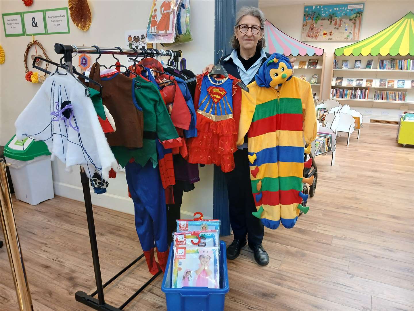 Librarian Lea Rickard with costumes at Stamford Library