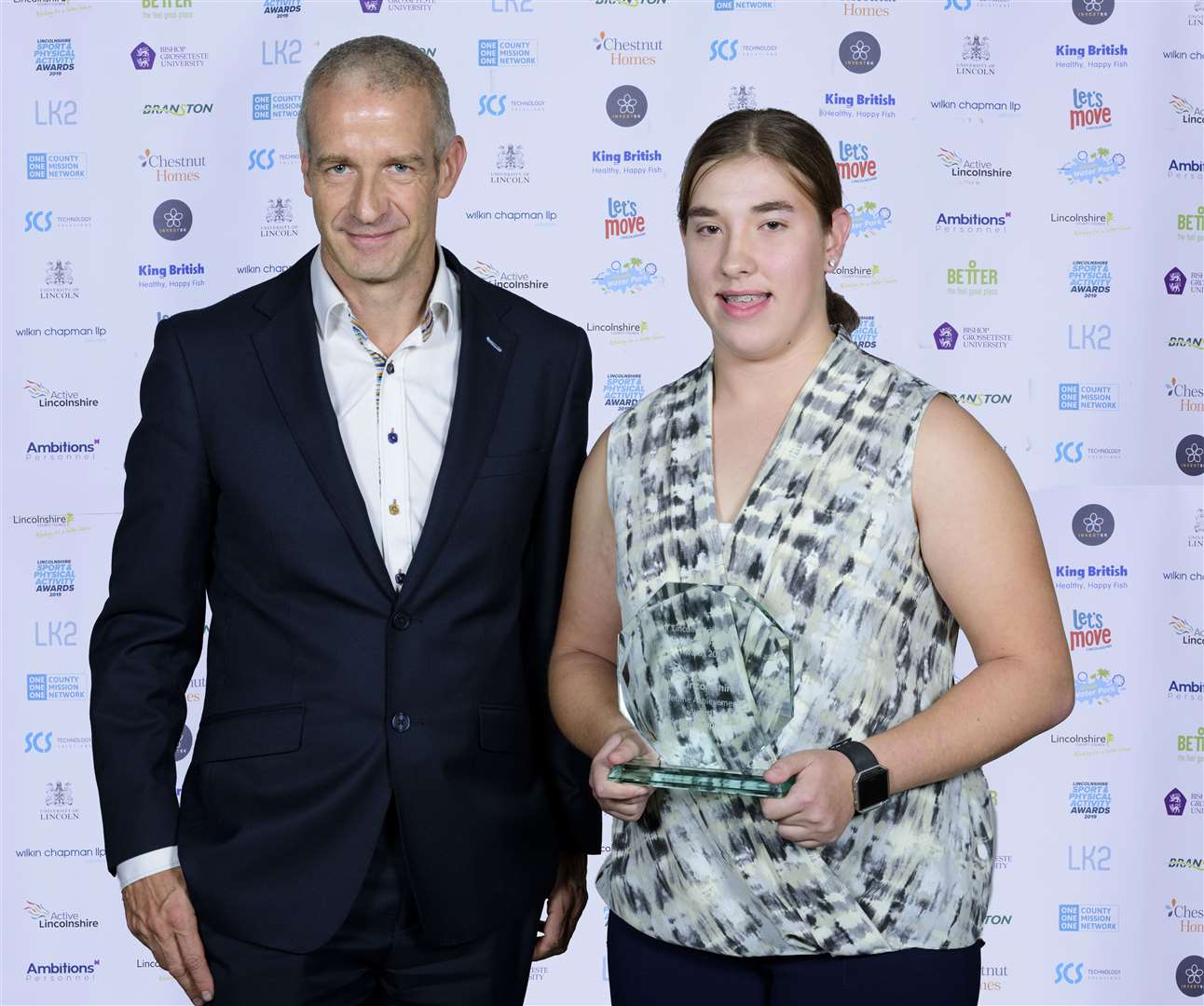 Abigail Sharples, of Lincolnshire Throws Academy, accepts the Active Lincolnshire Lifetime Achievement Award on behalf of Geoff Capes from Lee Wallhead, financial controller for pharmaceutical firm Beaphar UK Ltd. Photo supplied by Chris Vaughan Photography.