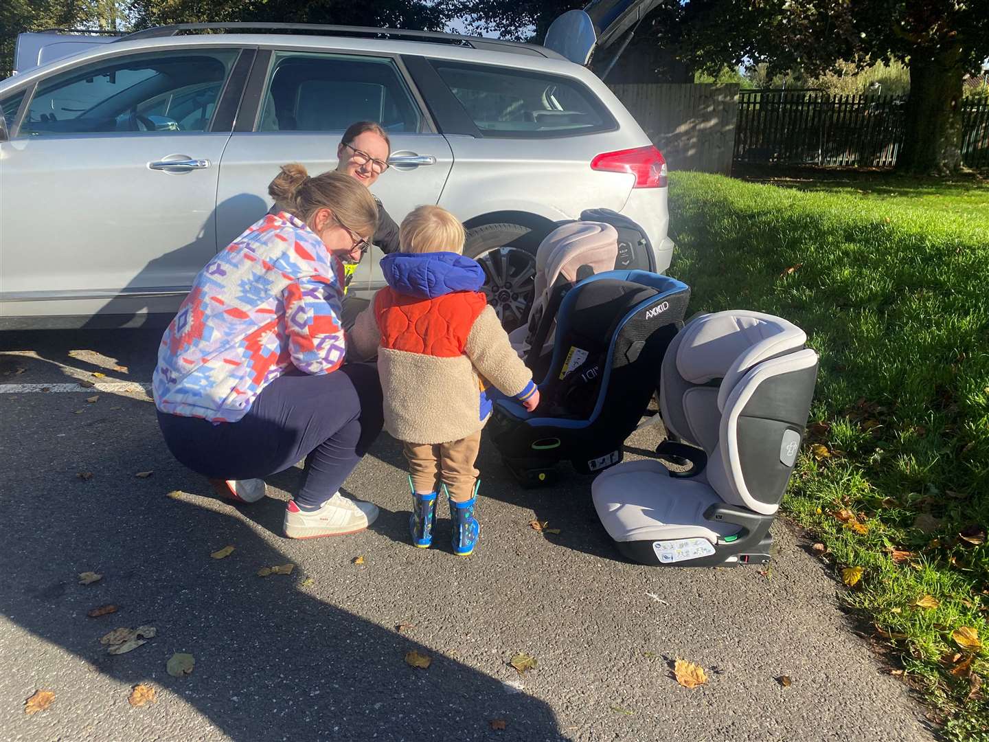 Shannon showing Harry and his mum the car seats.