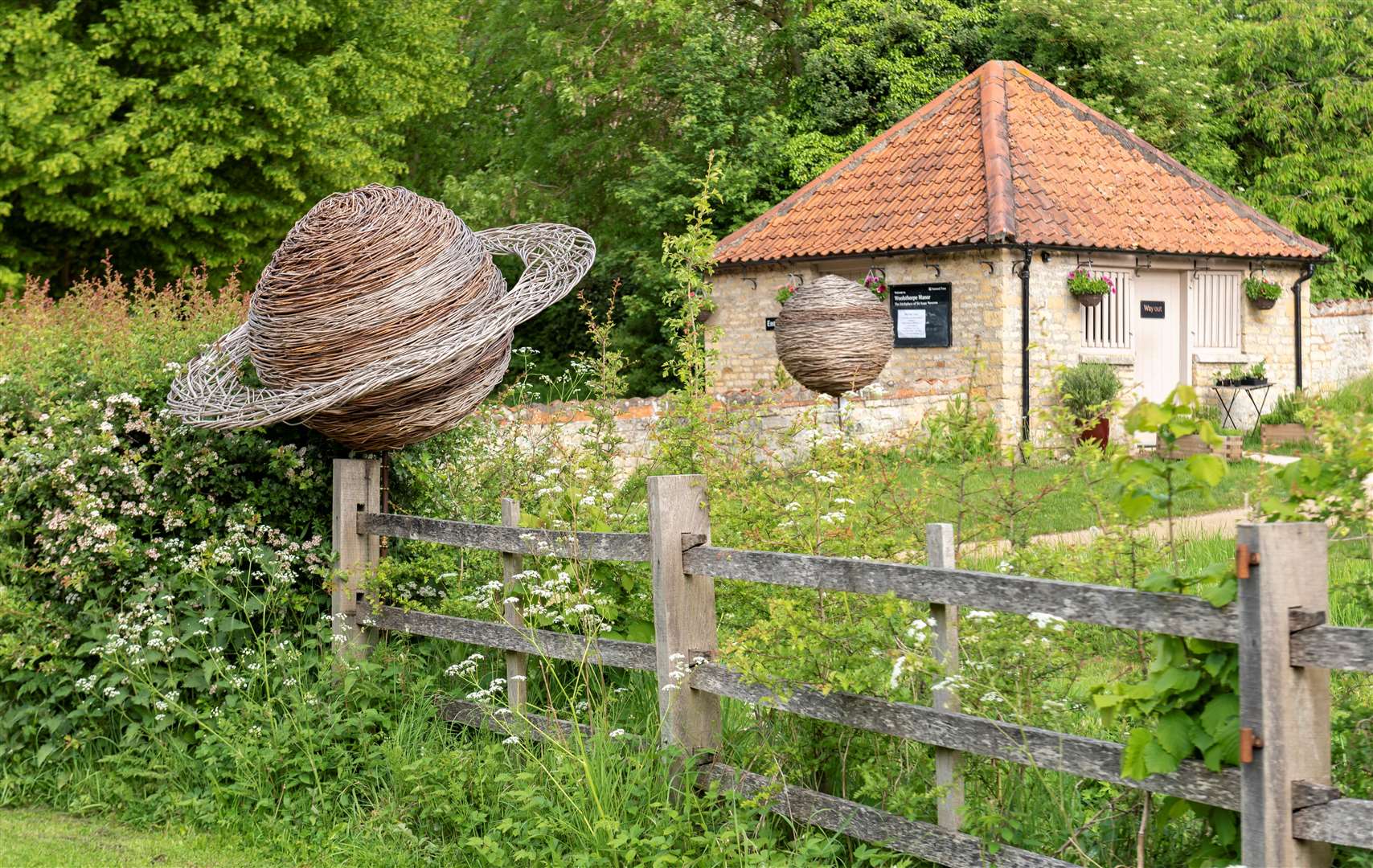 Willow planet sculpture in the garden at Woolsthorpe Manor, Lincolnshire. Woven by volunteers during a willow waving workshop on a community project. Woolsthorpe was home to the world-famous scientist and mathematician Sir Issac Newton.