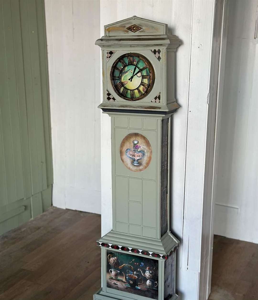 A grandfather clock has a Mad Hatter’s Tea Party theme from Alice In Wonderland