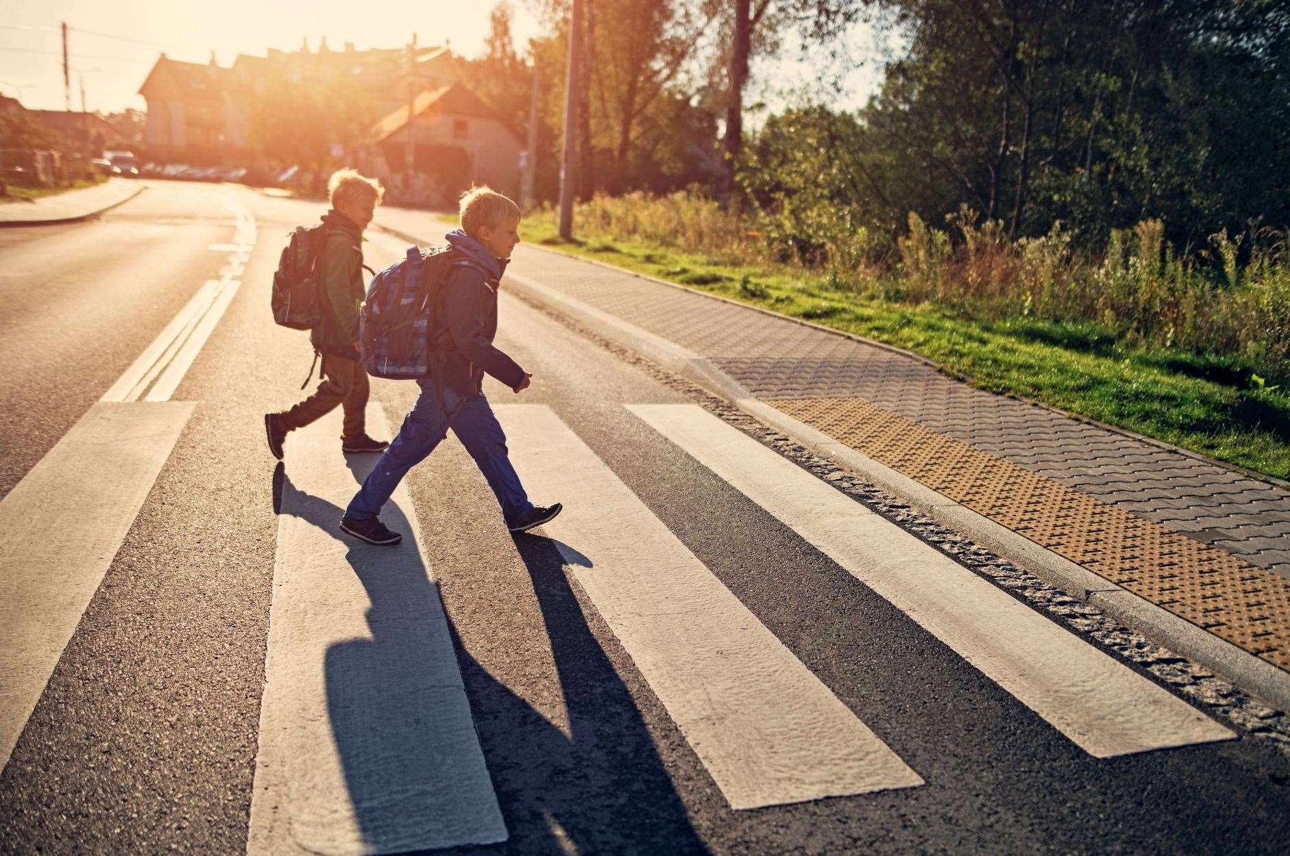Two school boys walking on a zebra crossing on way to school. Photo: istock/Imgorthand