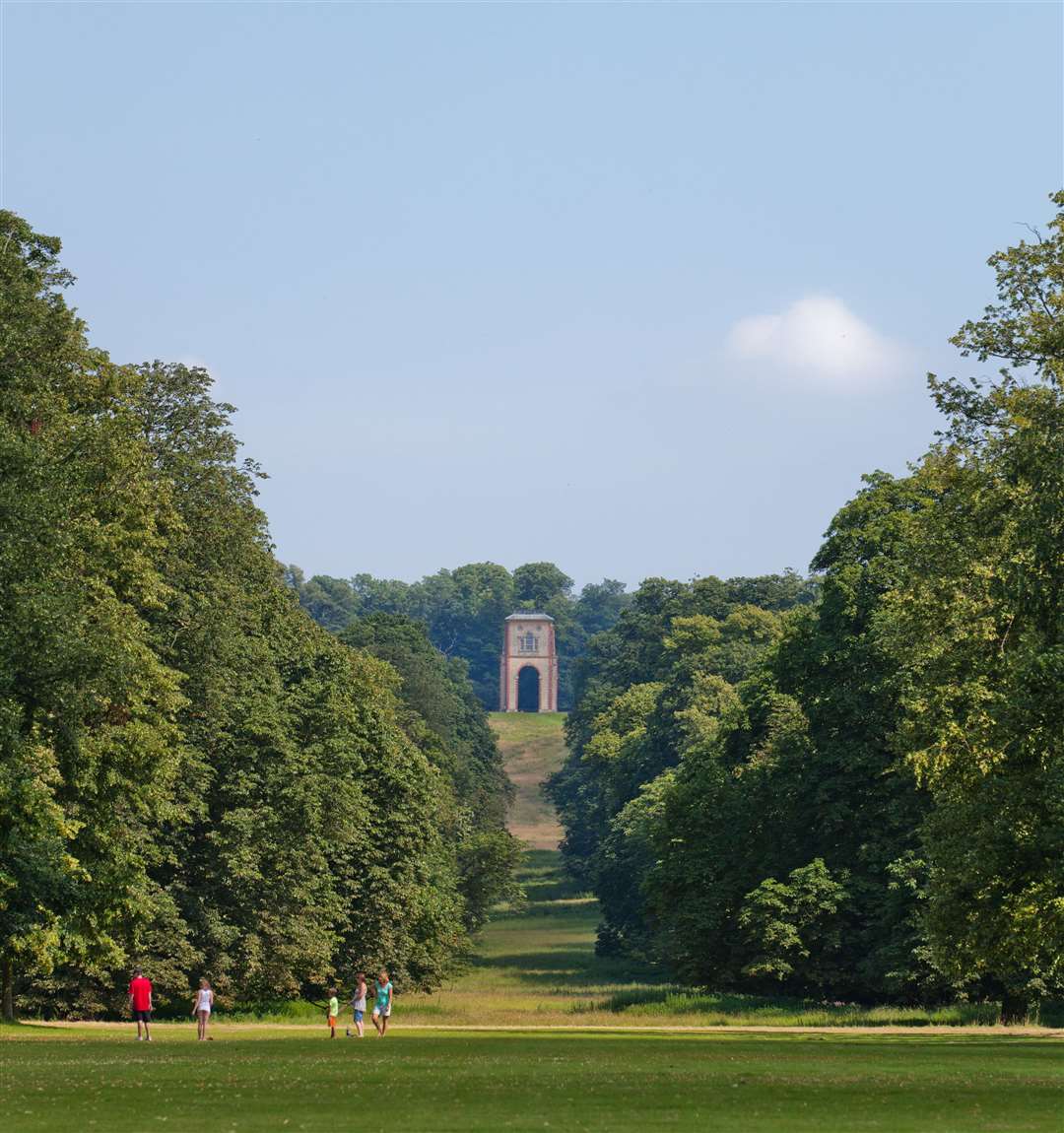 Visitors playing in the garden, with the Belmount Tower in the distance at Belton House