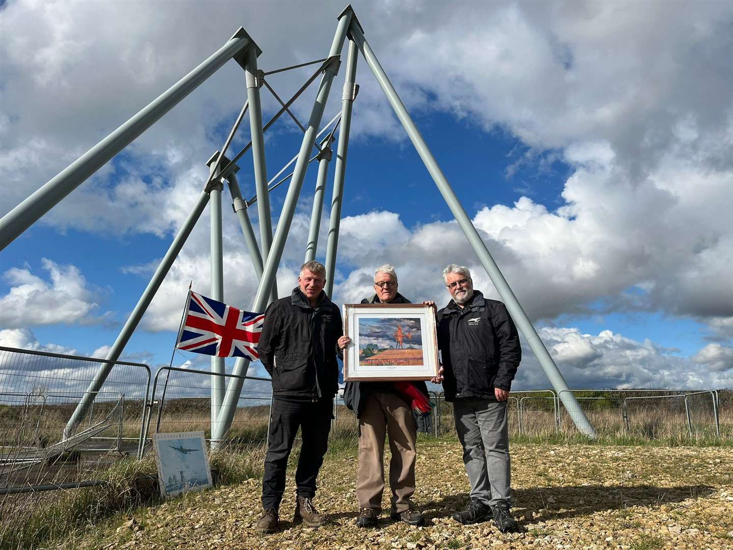 Chairman of the Bomber County Gateway Trust, Ken Sadler, and landowner, Charles White, present Laurence Goff with a special framed print in recognition of his monumental individual fundraising efforts for the On Freedom's Wings project.