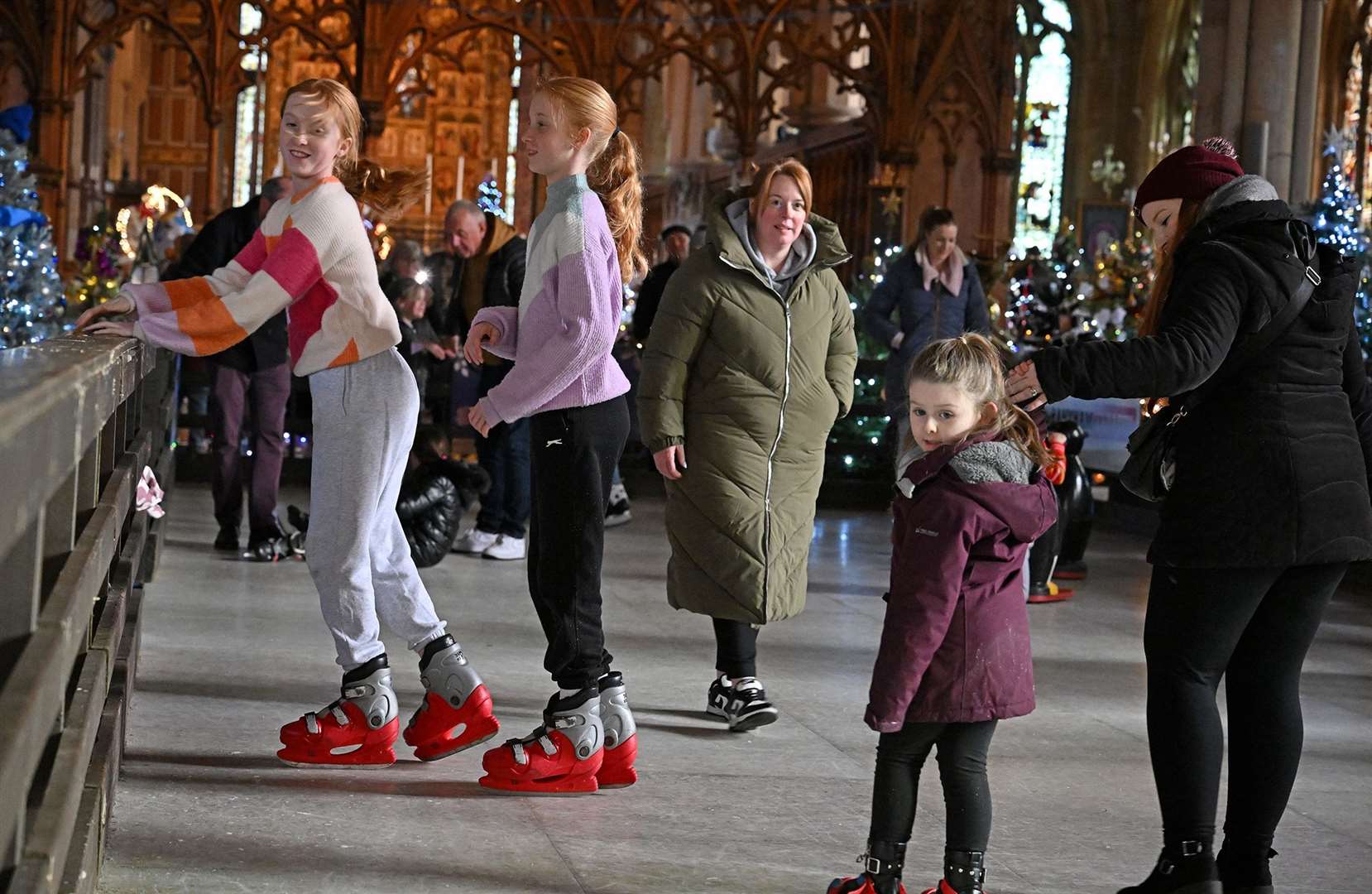 Visitors enjoying the St Wulfram's Christmas Tree Festival and skating rink.